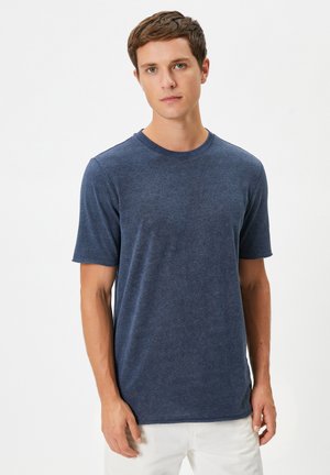 Camiseta de manga corta azul marino con cuello redondo, que presenta una tela suave y texturada y un corte relajado. Ideal para usar en la vida diaria.