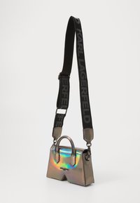 Holographic mini handbag with a structured design, a top handle, and a detachable black strap featuring the logo in bold lettering.
