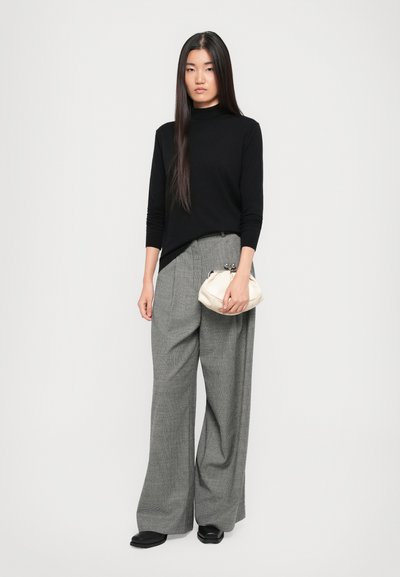 Schwarzes Langarmoberteil, graue karierte weite Hose und eine cremefarbene Clutch. Glatte Texturen und klare Linien, mit einem figurbetonten Rollkragen-Design.