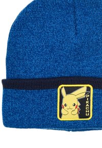 Niebieska dziana czapka z granatowym mankietem, z naszywką Pikachu na żółtym tle. Faktura jest miękka i elastyczna.