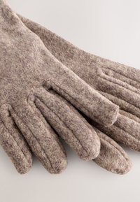 Gants en laine de couleur marron clair avec une surface douce et texturée. Comprend quatre sections pour les doigts et un poignet non élastique.