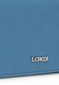 Billetera de cuero texturizado azul con el logo plateado "L.CREDI". Detalle de costura visible a lo largo de los bordes. Forma rectangular compacta.
