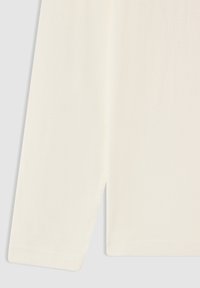 Długi, kremowy rękaw z materiału, z widocznym szwem i prostym wykończeniem, na jasnoszarym tle.