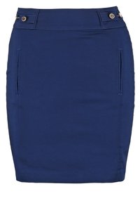 Falda lápiz azul marino hecha de una tela suave; cuenta con dos bolsillos laterales y botones decorativos en la cintura. Diseño a medida.