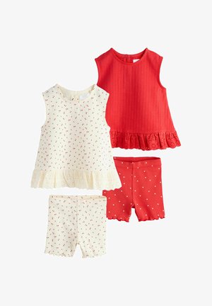 Twee tanktops en twee korte broeken. Eén top is creme met een rood stippenpatroon en gerimpelde zoom, de andere is effen rood met een gestructureerde stof.