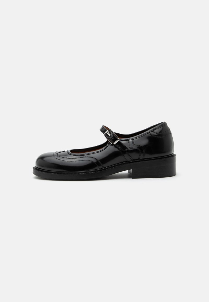 Chaussure Mary Jane en cuir verni noir avec un petit talon bloc et une bride à boucle argentée, vue de profil sur fond blanc.