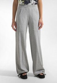Pantalones de pierna ancha en gris claro con cintura elástica y dos bolsillos delanteros, confeccionados en tela suave, con un corte holgado y dobladillos ajustables.