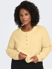 Gul strikket genser med rund hals, lange ermer og fem hjerteformede knapper foran. Myk tekstur og avslappet passform.