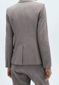 Grau maßgeschneiderte Blazer mit einer glatten Textur, einer einfachen Belüftung auf der Rückseite und vier Knopfakzenten an den Manschetten. Der Stoff hat ein dezentes Muster.