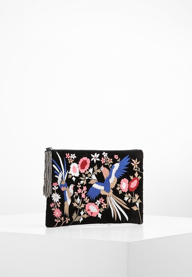 Czarna saszetka na zamek błyskawiczny z kolorowymi haftowanymi ptakami, różowymi kwiatami oraz koralikowym chwostem z boku, wyeksponowana na białej powierzchni.