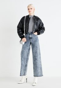 Melnas ādas bomber jaka, pelēks ribots topiņš, augsta vidukļa gaiši zila denim platā kāju bikses, baltas augstpapēžu norādītas kurpes. Sudraba rokassoma.