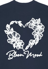Sweatshirt marine avec un design en forme de cœur floral blanc et le texte "Bloom Mood". Le tissu semble doux, avec un col rond et un ourlet côtelé.