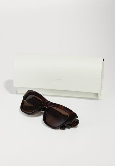 Burberry sunglasses with dark brown tortoiseshell frame, oversized square shape, and gradient lenses, accompanied by a white leather case.