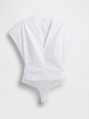 Witte body met een diepe V-hals, brede mouwen en een lage rug. Gemaakt van een soepele stof met een doorzichtig onderste gedeelte.