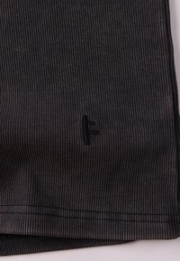 Μαύρο ριμπ ύφασμα με διακριτική υφή, που διαθέτει ανάγλυφο λογότυπο. Οι άκρες είναι ραμμένες аккуратно, δημιουργώντας ένα καθαρό τελείωμα.