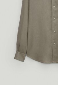 Langærmet skjorte i et afdæmpet olivengrønt stof med en struktureret krave, knappelukning foran og manchetter på ærmerne. Glat tekstur.