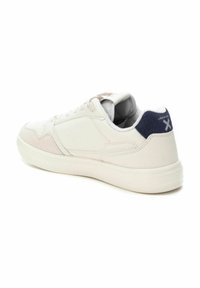 Zapatilla blanca con cuero liso y acentos de gamuza, con cuello acolchado y un detalle trasero azul, que presenta una punta redondeada y suela de goma.