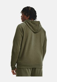 Olivgrüne Kapuzenjacke mit Kordelzug, gerippten Bündchen und Saum. Hergestellt aus weichem Stoff mit glatter Textur, für optimalen Tragekomfort.