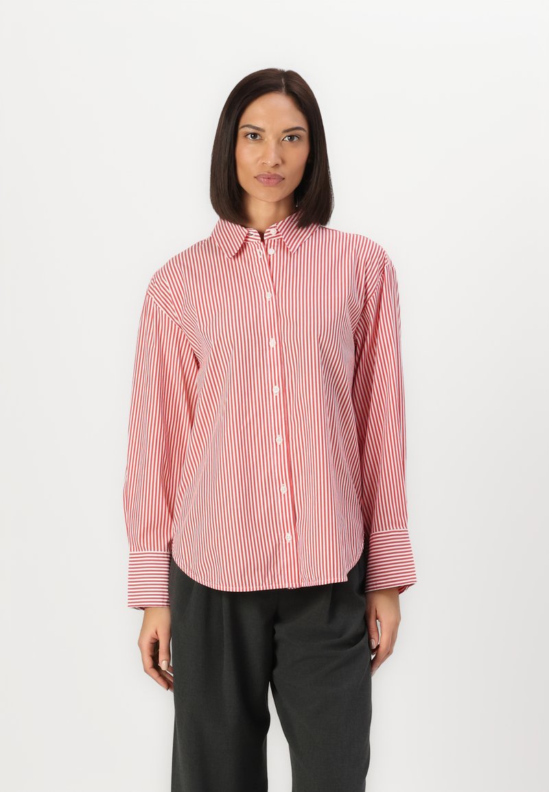 Camicia a righe rossa e bianca con colletto, maniche lunghe e polsini larghi; tessuto liscio e vestibilità comoda.