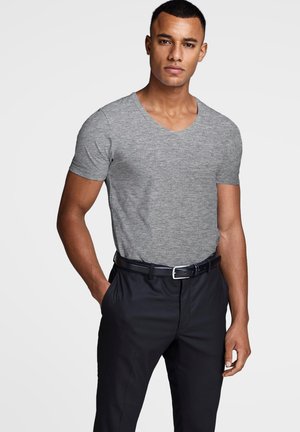 Gray short-sleeve V-neck t-shirt in soft fabric, paired with dark fitted trousers and a black belt. Clean design and neutral colors.