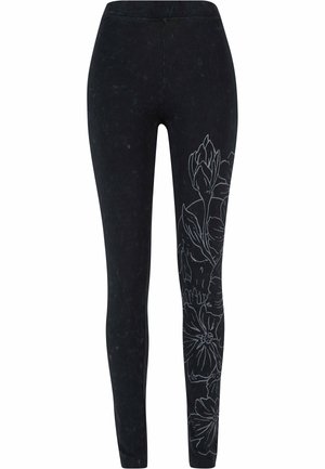 Sorte leggings med en blomsterprint i hvid langs siden, lavet af blødt materiale med en glat tekstur og et tætsiddende design.