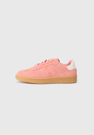 Pink suede sneaker with a gum rubber sole, rounded toe, lace-up front, and white heel tab. Features a stitched design on the side.