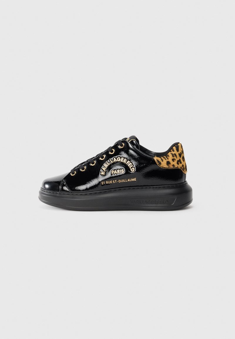 Zwarte gepatenteerde leren sneaker met een leopardprint hiel, gouden oogjes en de tekst "KARL LAGERFELD PARIS" op de zijkant en een zwarte zool.