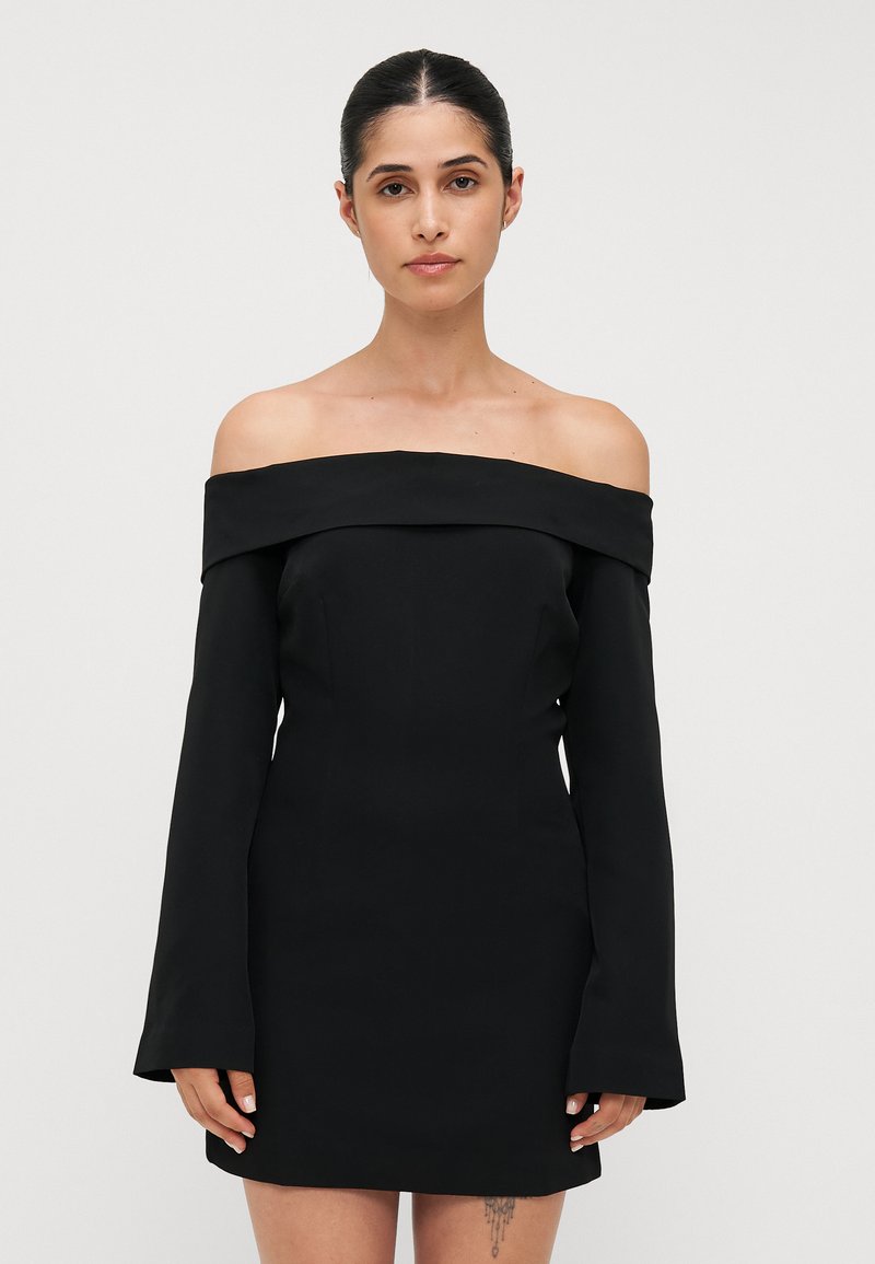 Svart av- skulderkjole med lange, tettsittende ermer. Laget av glatt stoff, har den en strukturert silhuett og minimale designdetaljer.