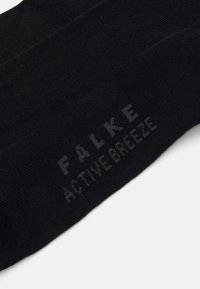 Svart FALKE Active Breeze sokk, med en glatt tekstur, ribbet design og subtil logo trykt i lysere nyanse på siden.