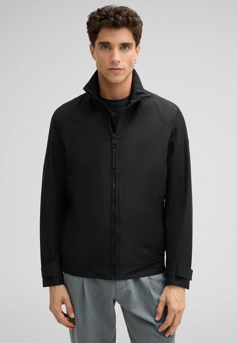 Schwarze Zip-Up-Jacke mit hohem Kragen, weicher Textur und minimalistischen Design. Verfügt über eine taillierte Passform und subtile Nähte.