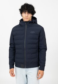 Marineblau gepolsterte Jacke mit Kapuze, Reißverschluss und Logodetail. Verfügt über strukturierten Stoff, elastische Bündchen und Seitentaschen.
