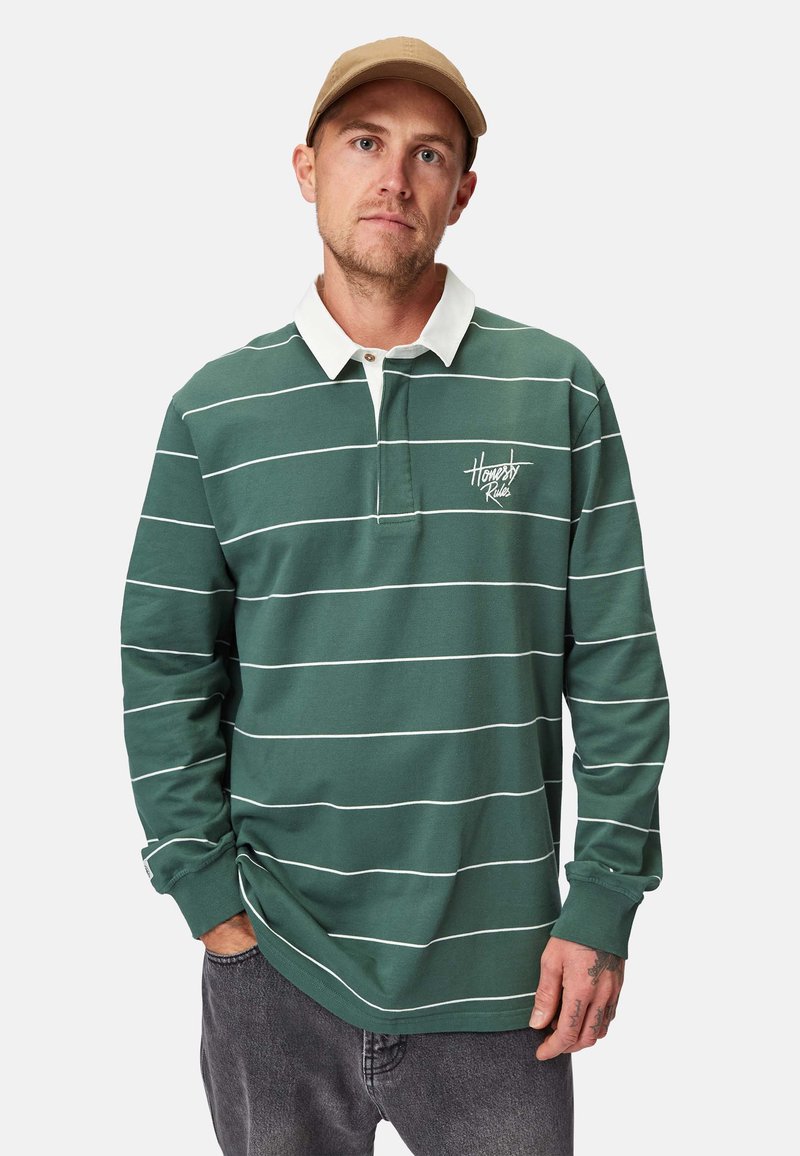 Grünes Langarm-Polo mit weißen horizontalen Streifen, ausgestattet mit einem weißen Kragen und besticktem Logo. Lässige Passform mit gerippten Bündchen.