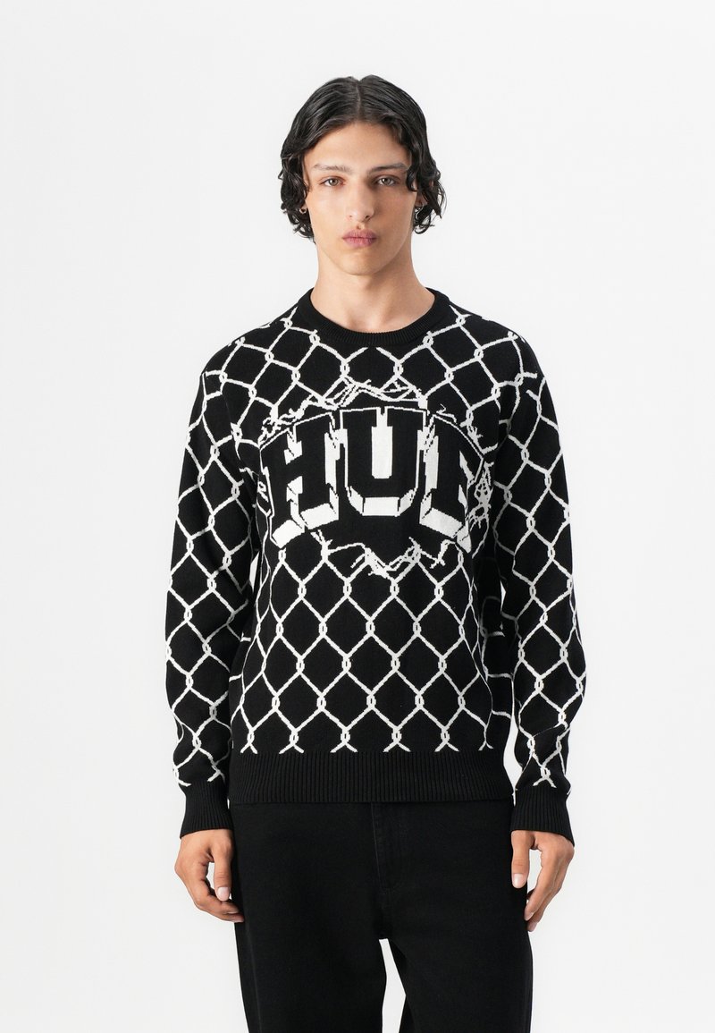 Sort strik-knit sweater med et hvidt diamantmønster, et stort "HUF" logo i centrum samt ribbede mansjetter og kant.
