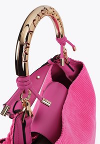 Borsa rosa con un'esterno testurizzato e una manico dorato lucido, con il nome del marchio inciso sul manico e una chiusura metallica.