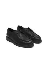 Pantofi din piele neagră cu un design al vârfului rotunjit, superior texturat și margine cusută. Au o talpă din cauciuc cu modele de aderență și șireturi decorative.
