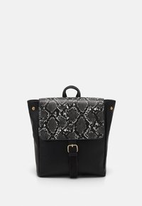 Schwarzer Leder-Rucksack mit einem strukturierten Schwarz-Weiß-Schlangenhautdeckel, goldener Hardware, verstellbarem Schultergurt und Oberhandgriff.