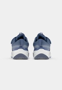 Baskets de sport bleues avec une tige en tissu texturé, des accents réfléchissants, une semelle intermédiaire blanche contrastante et une semelle en caoutchouc à motifs.