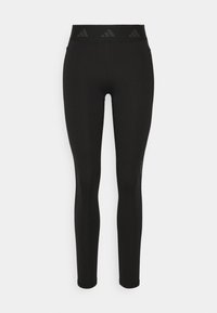 Leggings atléticos negros con una cintura alta que presenta un sutil patrón de logotipos en relieve. Tela suave y elástica, diseño de longitud completa.