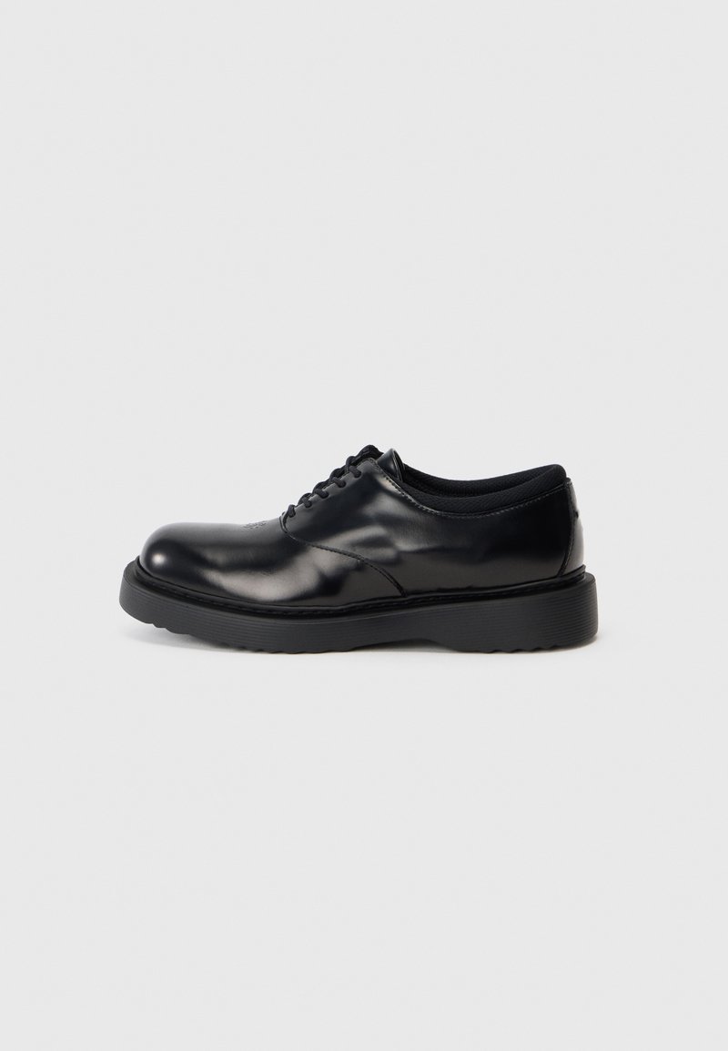 Schwarze Leder-Schnürschuhe mit abgerundeter Zehenpartie, glatter Oberfläche und einer dicken Gummisohle mit dezenten Rillen für besseren Halt.