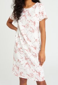 Blumen-Kurzarmkleid in hellem Creme mit pinkem botanischen Print. Hat eine lockere Passform und einen runden Ausschnitt. Der Stoff hat eine glatte Textur.