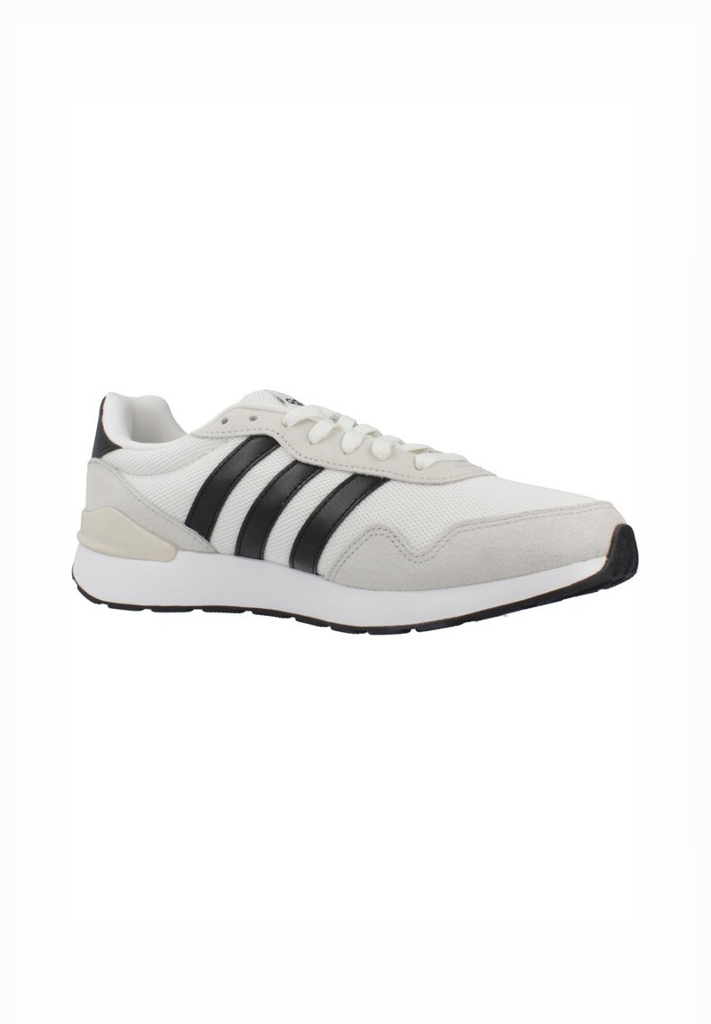 White athletic shoe with black stripes, suede and mesh materials, rubber sole, rounded toe, and minimalistic design.
