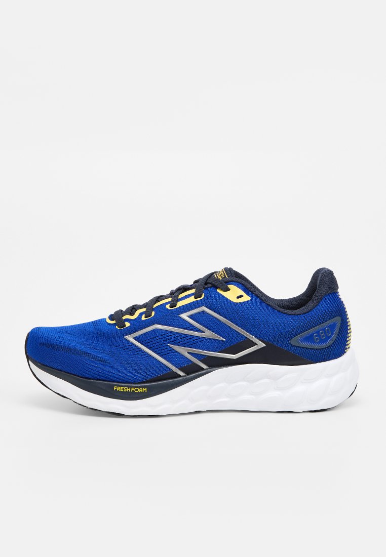 Zapatilla deportiva azul con parte superior de malla texturizada, acentos plateados y detalles en negro. Presenta una suela blanca acolchada y un logo amarillo "FRESH FOAM".