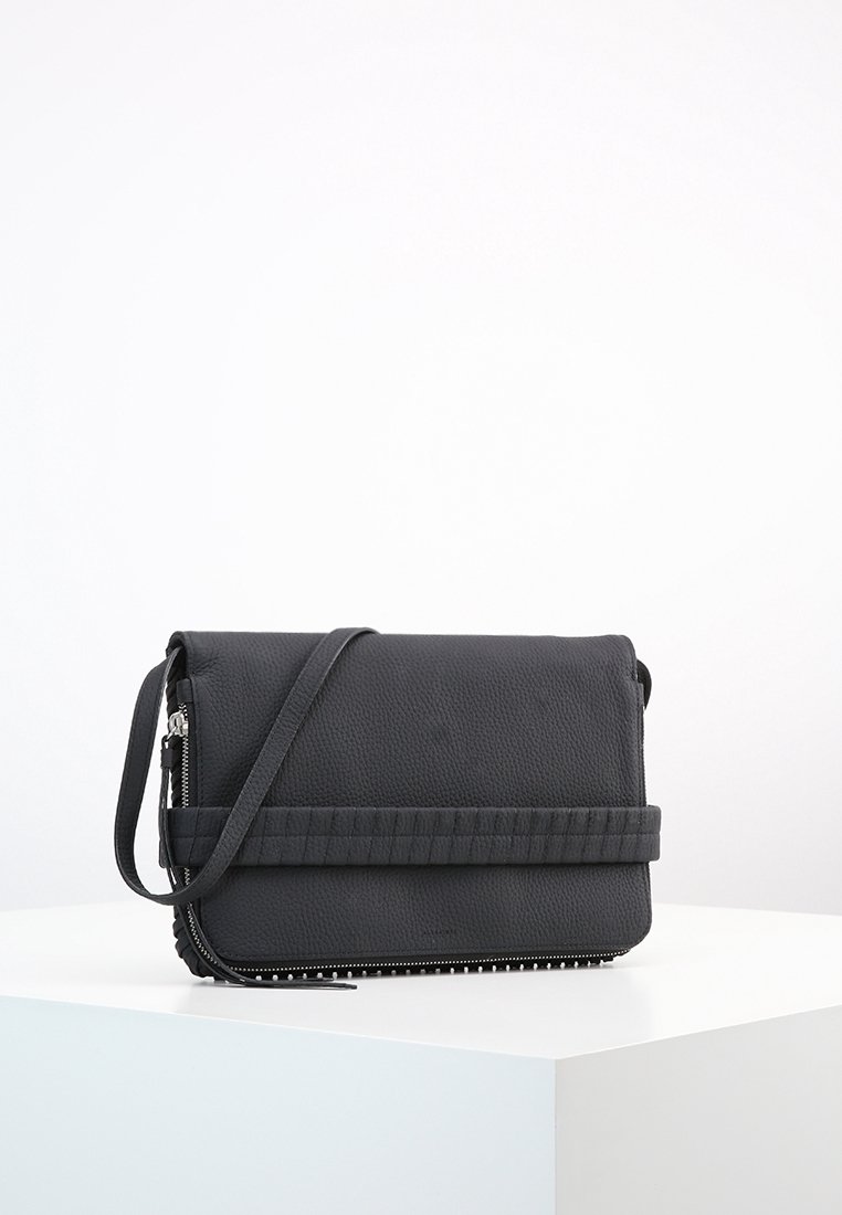Borsa a tracolla nera con una finitura testurizzata e una chiusura con zip, caratterizzata da una tracolla piatta e un accento trapuntato sulla parte anteriore, di dimensioni compatte.