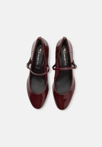 Chaussures Mary Jane en cuir verni bordeaux avec un bout arrondi et une seule sangle réglable. Semelle plate avec intérieur noir lisse. Taille 37.