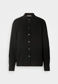 Chemise noire à boutons, en tissu texturé, avec un col classique, des manches longues et une patte de boutonnage sur le devant avec des boutons en argent.