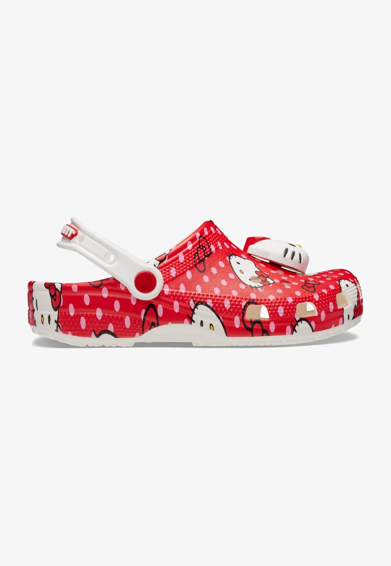 Red clogs featuring a Hello Kitty design with white polka dots, molded plastic material, adjustable strap, and a textured surface.