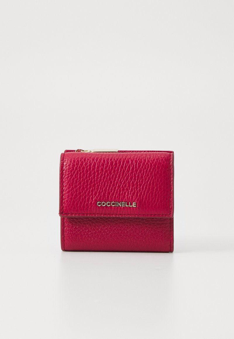Red leather wallet with a textured finish, featuring a fold-over design and a gold "Coccinelle" logo on the front. Zippered compartment above.