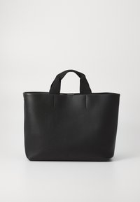Sac fourre-tout noir avec une finition en cuir lisse, deux poignées en tissu courtes et un design minimaliste. Présente un logo discret sur le bas à l'avant.