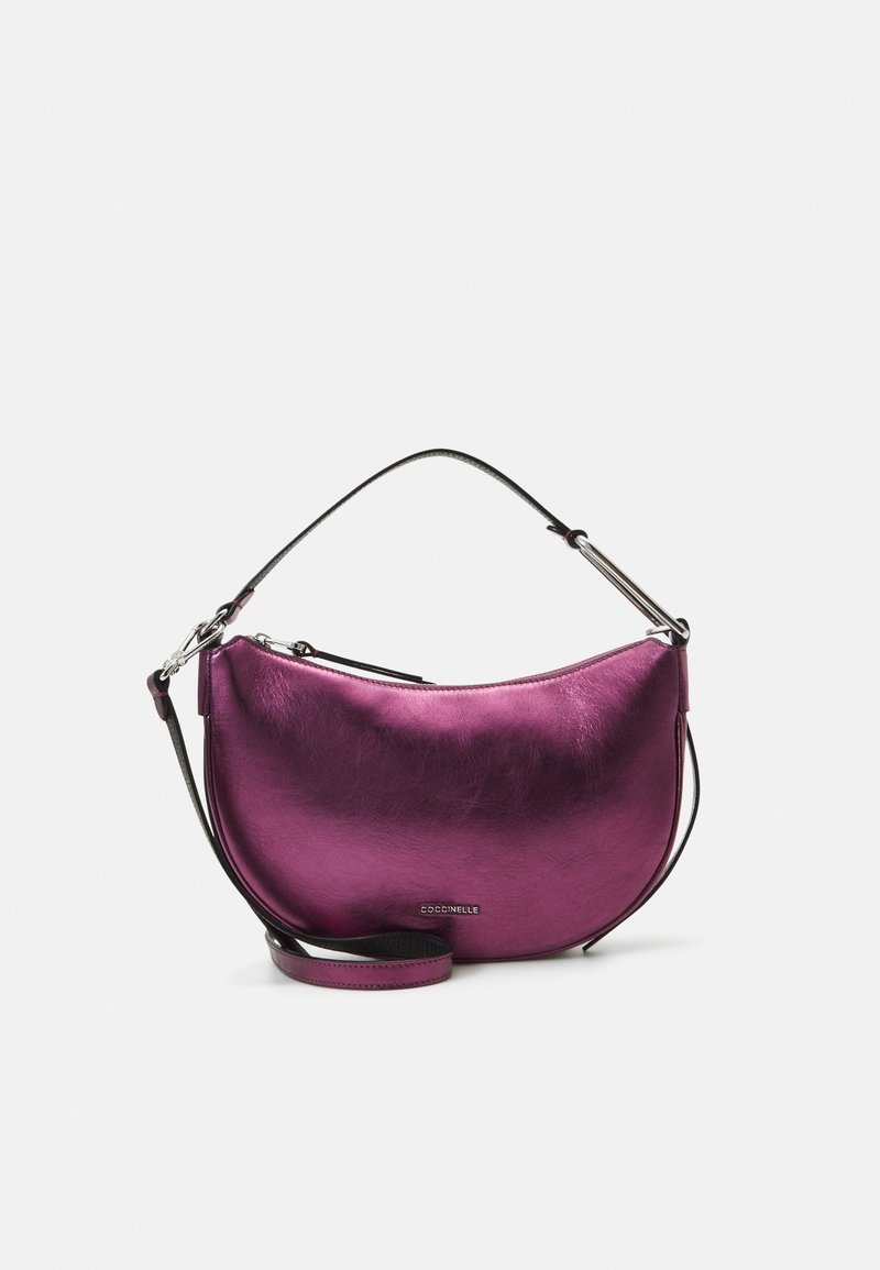 Sac à main violet brillant en forme de demi-lune avec une fermeture éclair argentée, une bandoulière noire réglable, et un petit logo de la marque au centre devant.