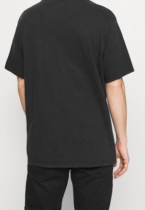 T-shirt noir en coton, coupe décontractée avec des manches courtes, col rond et ourlet droit. Pas de logos ou de motifs visibles.